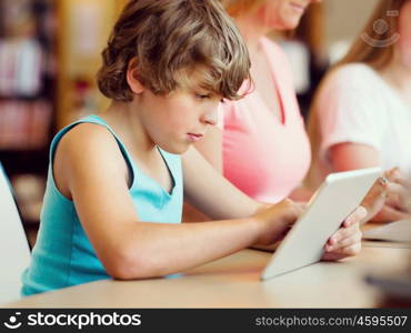 Boy with his famile on background in library with computer. Boy in library with computer