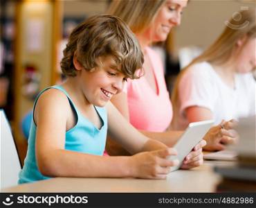 Boy with his famile on background in library with computer. Boy in library with computer