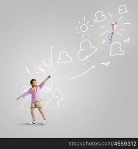 Boy with kite. Little boy playing with kite against gray background. Childhood concept