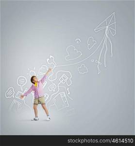 Boy with kite. Little boy playing with kite against gray background. Childhood concept
