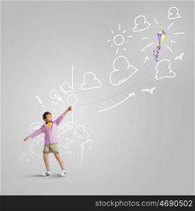 Boy with kite. Little boy playing with kite against gray background. Childhood concept