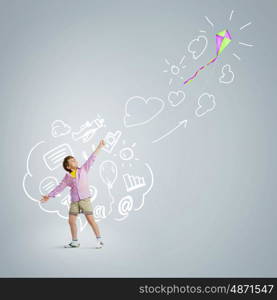 Boy with kite. Little boy playing with kite against gray background. Childhood concept