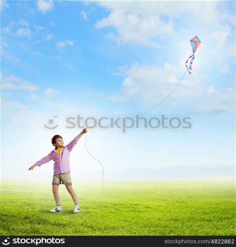 Boy with kite. Little boy playing with kite on meadow. Childhood concept