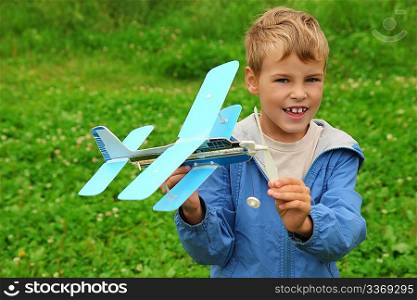 boy with toy airplane in hands outdoor