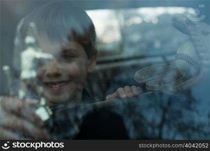 Boy with trophy through window