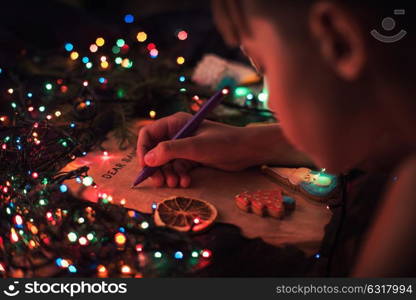 Boy writes a letter to Santa, cristmas background. Letter to Santa