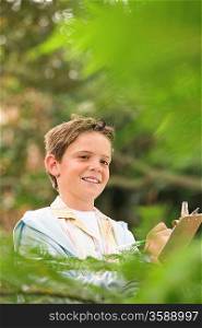 Boy Writing in Forest
