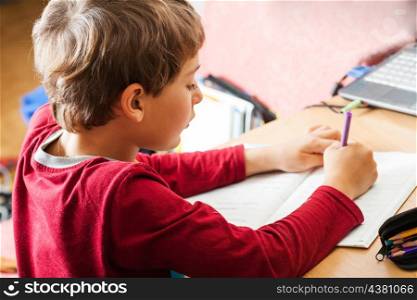 boy writing indoors