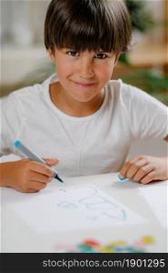Boy writing letters on preschool screening test.. Screening test for preschool children.