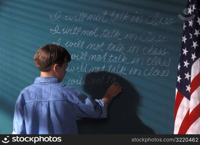 Boy Writing On Chalkboard As Punishment