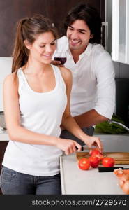 boyfriend sliceing tomottos with his girlfriend in kitchen..