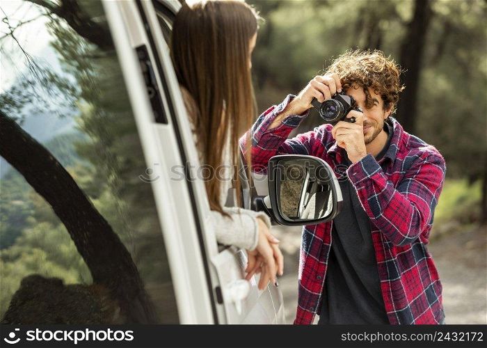 boyfriend taking pictures girlfriend car while road trip