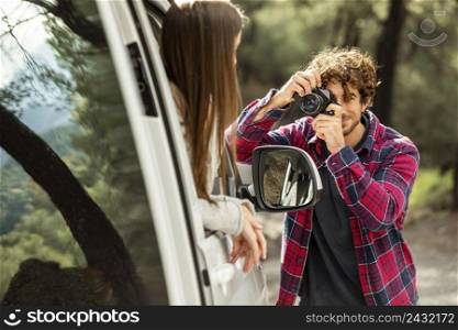boyfriend taking pictures girlfriend car while road trip