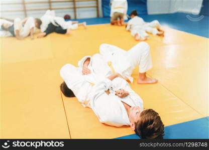 Boys in uniform, kid judo training. Young fighters in gym, martial art for defense. Boys in uniform, kid judo training