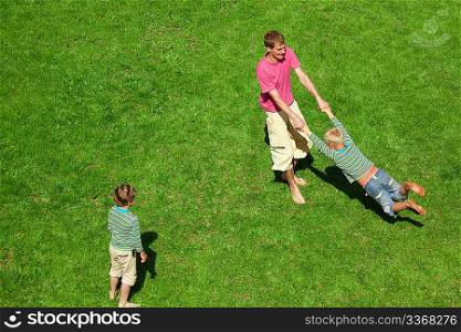 Boys play with the man outdoor. The Top view.