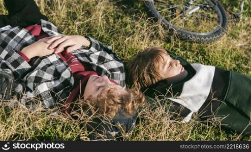 boys resting grass while riding their bicycles