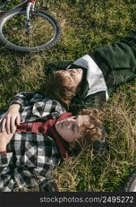 boys resting grass while riding their bikes