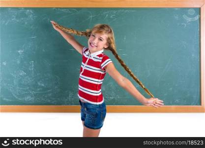Braided student blond girl playing in green chalkboard with braids at school classroom