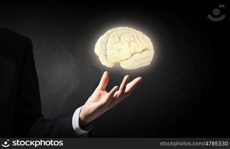 Brain in male hand. Businessman holding image of human brain in palm