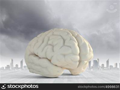 Brainstorming. Huge human brain against modern city background