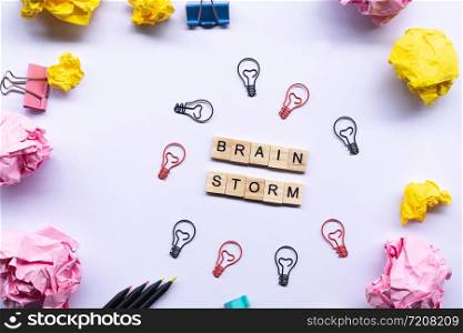 Brainstrom concept , word on wooden block surrounded by crumpled papers and light bulb paperclip