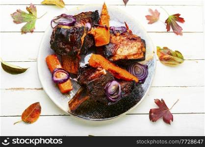 Braised beef ribs with pumpkin.Roasted veal meat with slices of pumpkin. Piece of baked beef ribs
