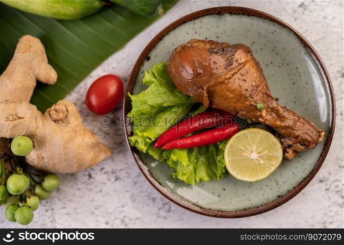 Braised chicken leg with lettuce chili and lime on a plate. Selective focus.
