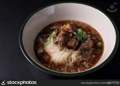 Braised pork nood≤s Thai street food isolated in black background