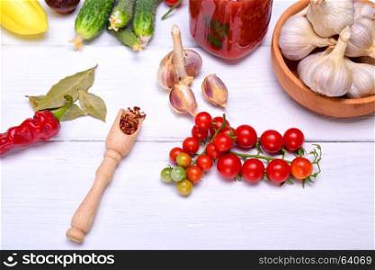 Branch of fresh red cherry tomato and garlic in white husk, top view