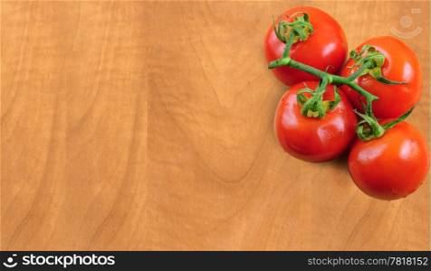 Branch of fresh tomatoes on wooden board