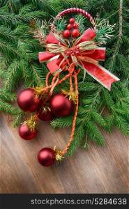 branch of green fir tree with christmas toys on wooden background