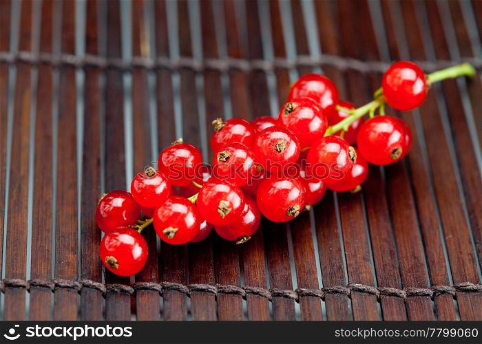 branch of red currants on a bamboo mat