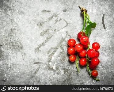 Branch of red currants. On a stone background.. Branch of red currants. On stone background.