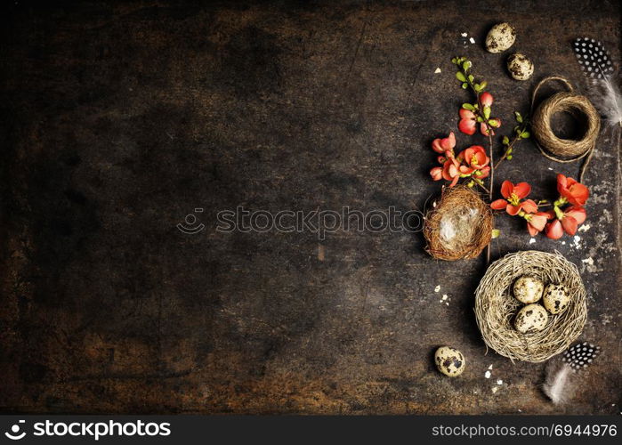branch with peach blooming flowers and easter decorations on aged table