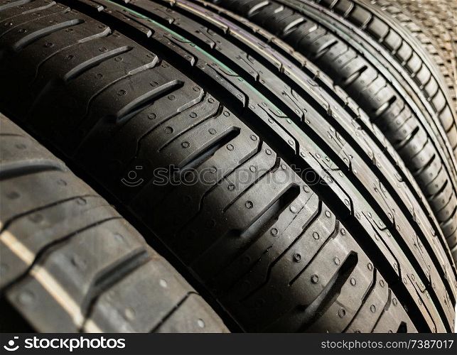 Brand new car tyres or tires lined up in a garage ready to be fitted to vehicles