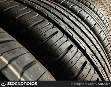 Brand new car tyres or tires lined up in a garage ready to be fitted to vehicles