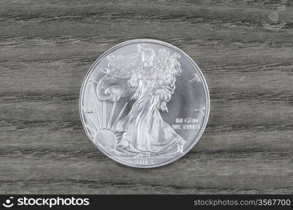 Brand new United States Silver Dollar - Walking Liberty- on Vintage White Oak wood serving as background