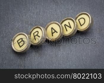 brand word in old round typewriter keys against gray slate stone