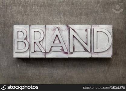 brand word in vintage letterpress metal type against a grunge steel sheet