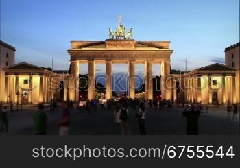 Brandenburger Tor in Berlin. Langzeit-Zeitraffer von der DSmmerung bis in die Nacht. Menschengruppen passieren den Pariser Platz in alle Richtungen.