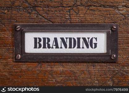 branding - file cabinet label, bronze holder against grunge and scratched wood, marketing concept