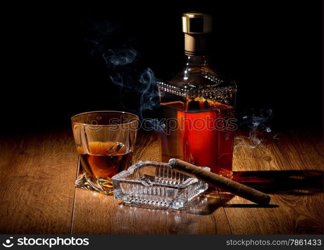 Brandy and cigar on ashtray on a wooden table