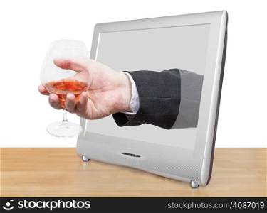 brandy glass in male hand leans out TV screen isolated on white background