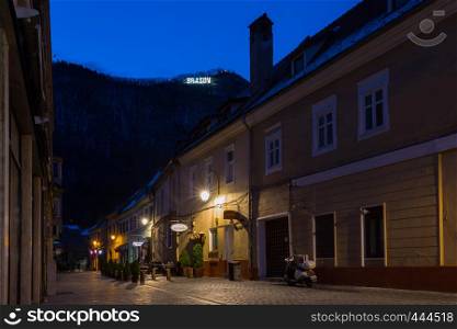 BRASOV, ROMANIA NOVEMBER 1, 2017: view of the street in the historic city center Brasov illuminated by the street lamps. BRASOV, ROMANIA, November 1, 2017