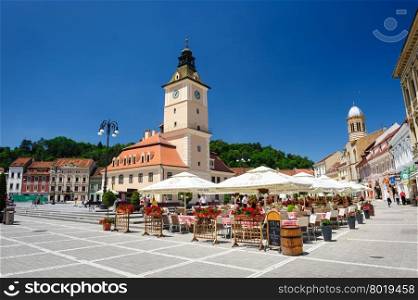 Brasov, Transylvania, Romania, 6th July 2015: Brasov Council Square is historical center of city, people walkinng and sitting at outdoor terraces and restaurants.