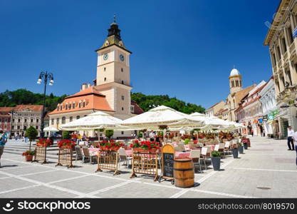 Brasov, Transylvania, Romania, 6th July 2015: Brasov Council Square is historical center of city, people walkinng and sitting at outdoor terraces and restaurants.