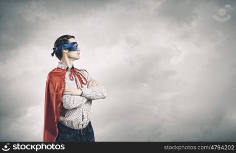 Brave superhero. Young confident superman in mask and cape