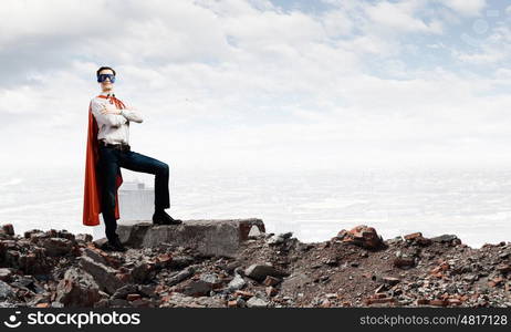 Brave superhero. Young confident superman in mask and cape