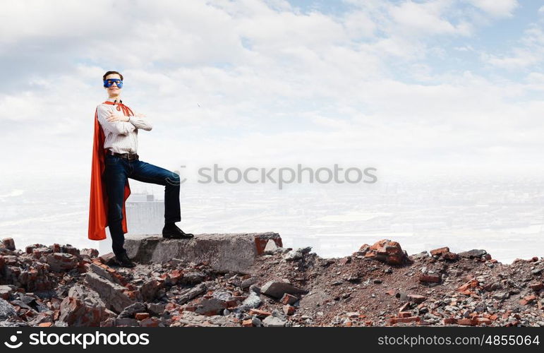 Brave superhero. Young confident superman in mask and cape