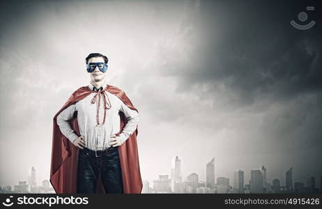 Brave superhero. Young confident superman in mask and cape